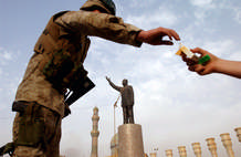 A Marine accepted a cigarette in Firdooz Square on the day when Baghdad fell to Allied forces